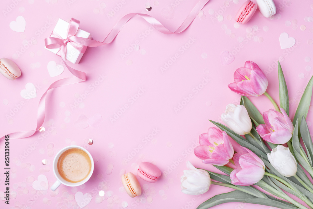 Fototapeta Poranna filiżanka kawy, ciasto macaron, prezent lub pudełko i wiosenne kwiaty tulipanów na różowym tle. Piękne śniadanie na Dzień Kobiet, Dzień Matki. Leżał płasko.