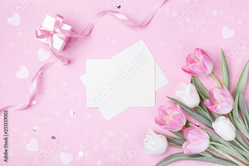 Women Day, Mother day background with envelope, gift box and beautiful spring tulip flowers on pastel pink desk. Flat lay. © juliasudnitskaya