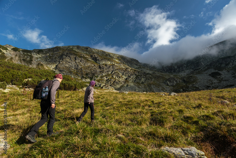 Couple of hikers on a trail in the mountains