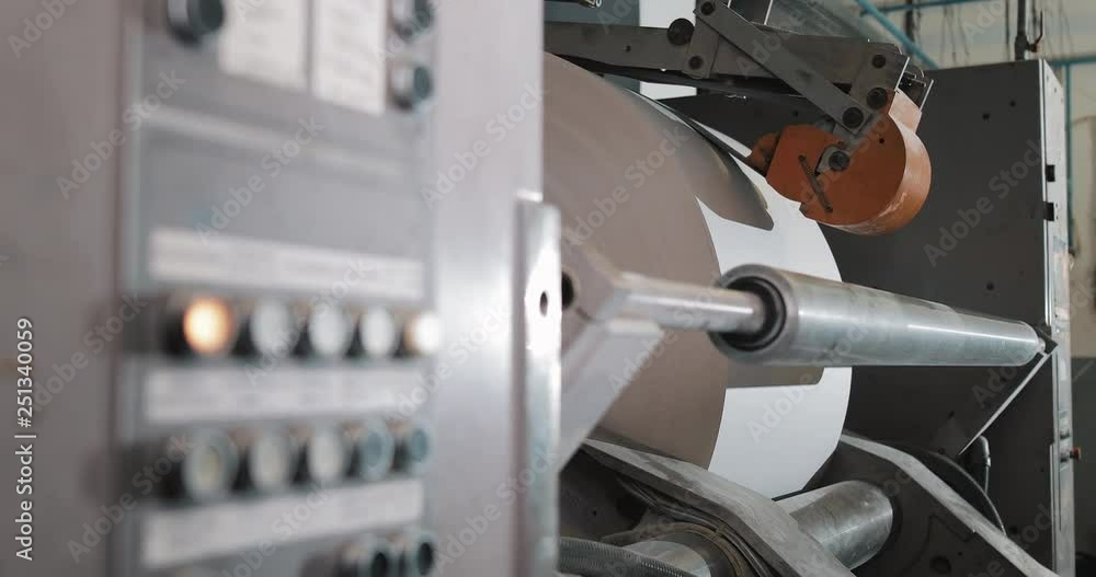 Plant on production of newspaper. Print machine roll in newspaper offset print production. Worker man in working in newspaper factory Plant on production of newspaper. Print machine roll in newspaper offset print production. Worker man in working in newspaper factory