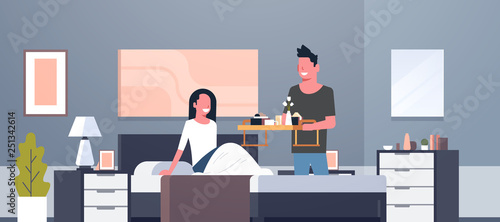 man bringing breakfast for his woman in bed happy 8 march womens day concept husband making surprise to wife modern bedroom interior flat horizontal