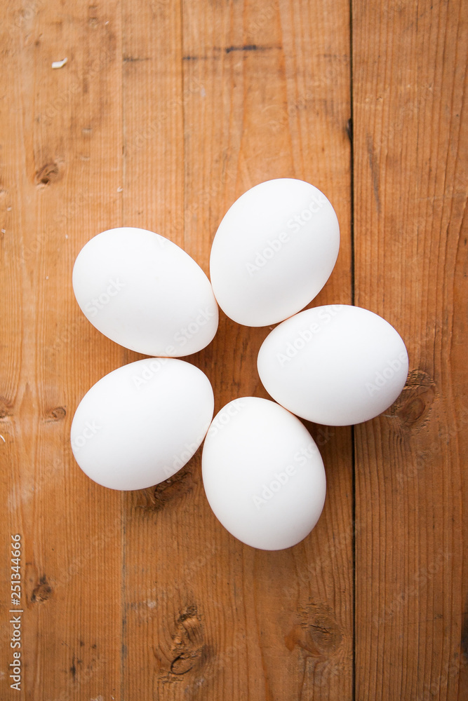 Five white eggs on a wood ground Five white eggs on a wood ground