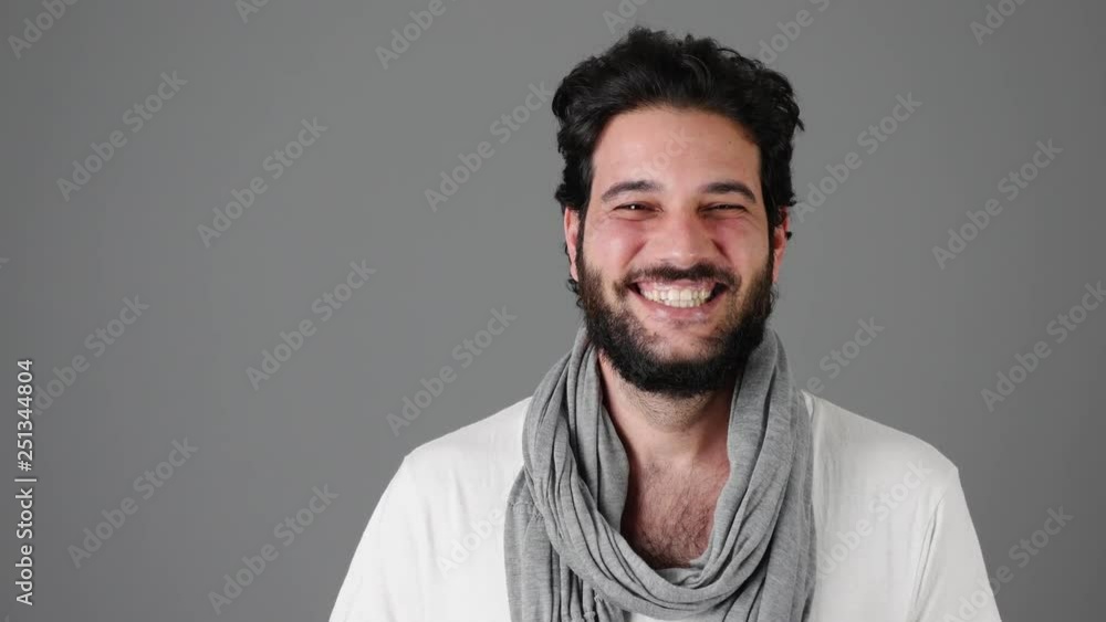 Excited young man laughing against gray background Excited young man laughing against gray background