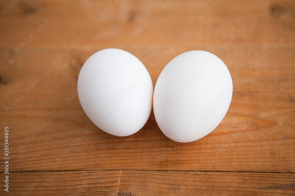 Two white eggs on a wood ground Two white eggs on a wood ground