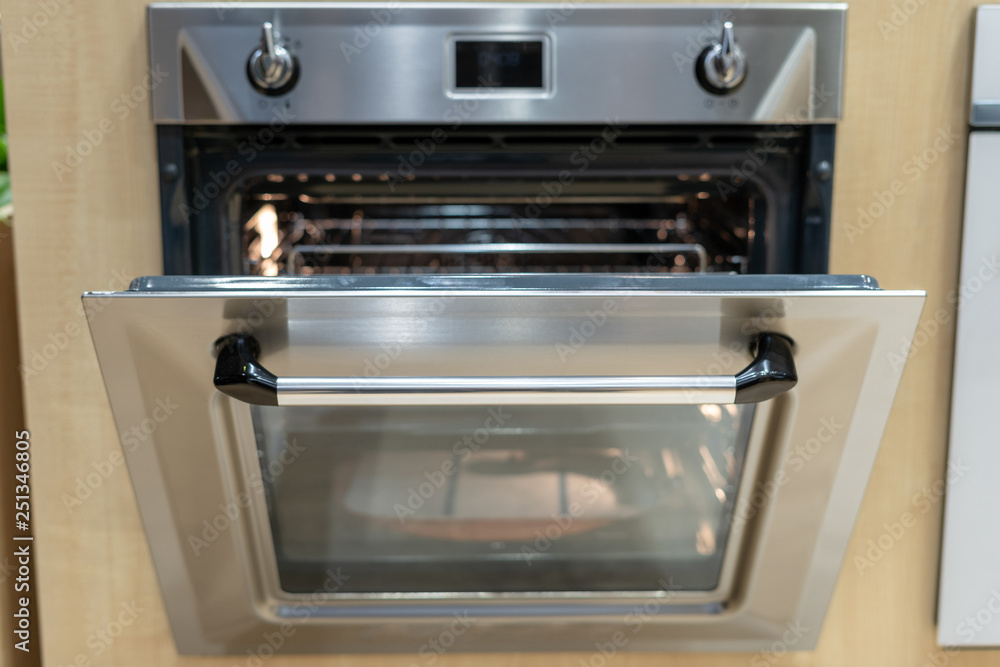 Open door on modern built-in oven in kitchen Open door on modern built-in oven in kitchen