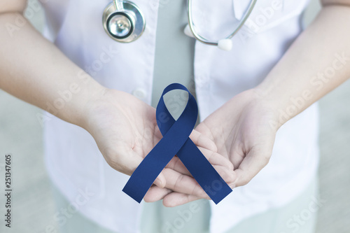 Royal dark navy blue ribbon awareness in doctor hand for Colorectal Cancer,Acute Respiratory Distress Syndrome (ARDS),Arthritis,Chronic Fatigue Syndrome, Colitis,Colon Cancer