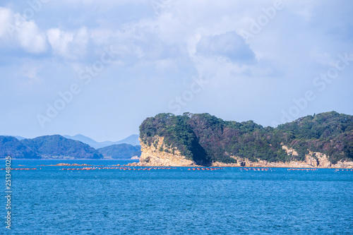 Many small islands over the blue ocean in sunny day, famous Kujukushima(99 islands) pearl sea resort islet in Sasebo Saikai National Park, Nagasaki, Kyushu, Japan. photo