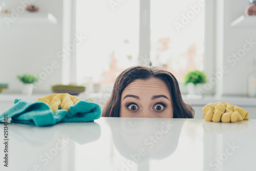 Portrait of her she nice cute lovely beautiful girlish funny shocked wavy-haired house-wife hiding behind shine glossy table in modern light white interior indoors photo