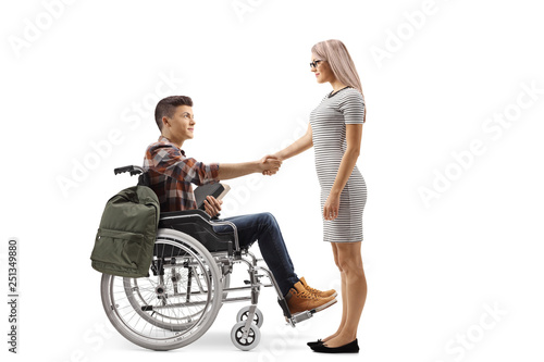 Male student in a wheelchair shaking hands with a young woman