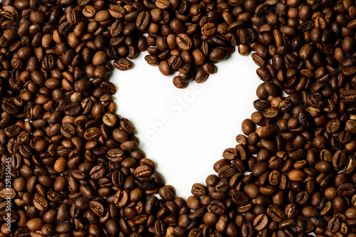Roasted brown coffee beans scattered on white table with a lot copy space for text. Flat lay composition. Close up, top view, background. 