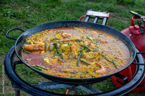 A large pan of seafood paella outdoors