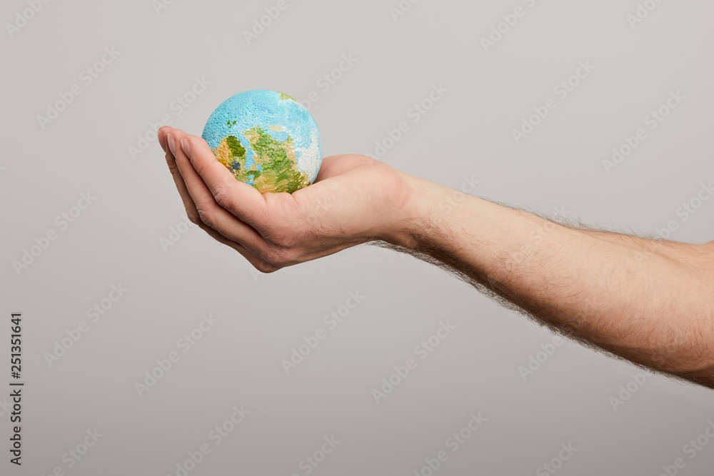 man holding planet model on grey background, earth day concept man holding planet model on grey background, earth day concept