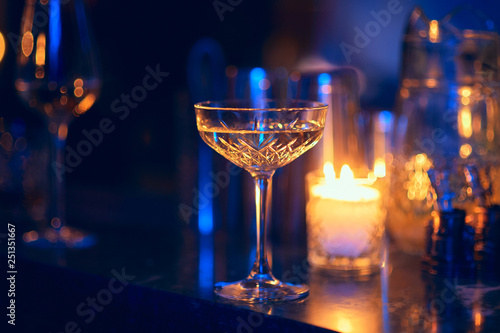 Vintage crystal glass on a blurred background. The atmosphere of a romantic dinner by candlelight.
