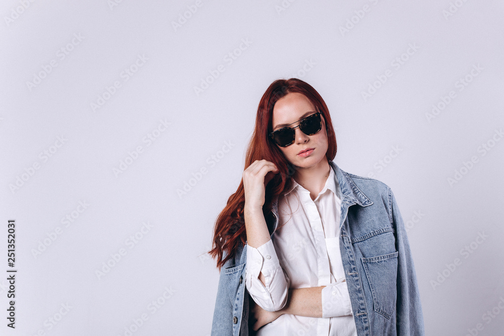 Portrait of young fashion gorgeous caucasian hipster girl with red headed hairstyle on white background in sun glasses. Beauty, commercial concept Portrait of young fashion gorgeous caucasian hipster girl with red headed hairstyle on white background in sun glasses. Beauty, commercial concept
