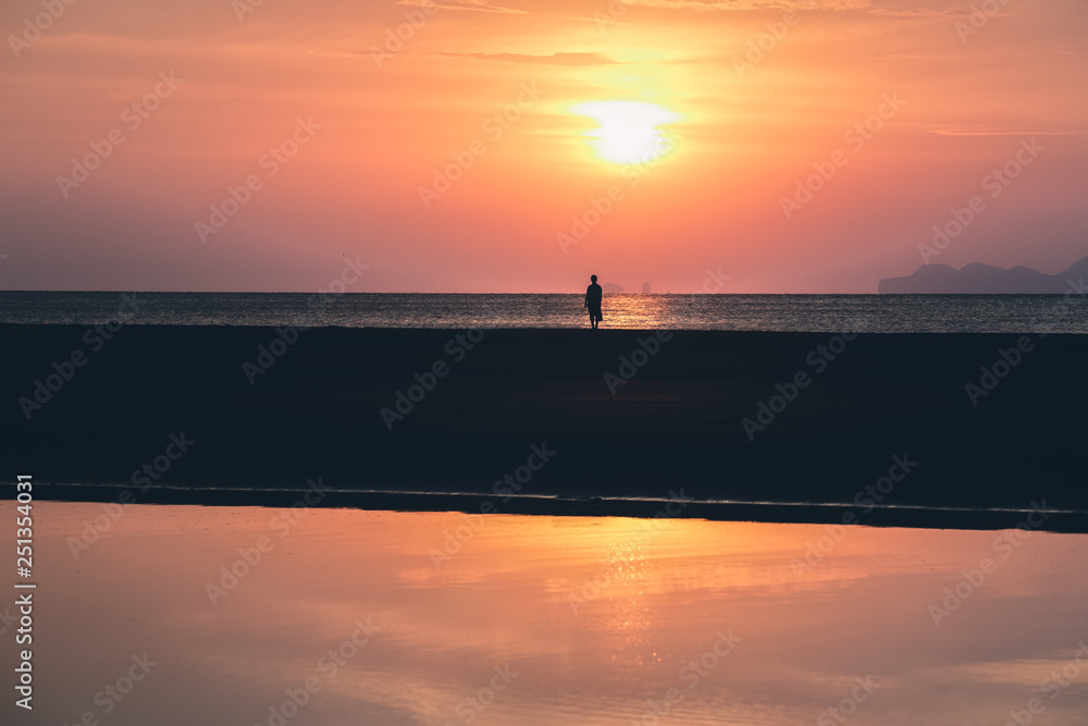 Women’s is lonely on the beach at sunset. Beautiful sky and clouds with reflection on water. She’s travel in summer holiday Women’s is lonely on the beach at sunset. Beautiful sky and clouds with reflection on water. She’s travel in summer holiday