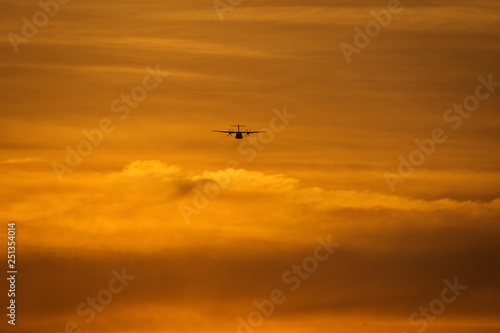 Small plane in the middle of the red clouds at sunset © danmir12