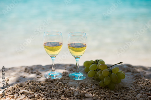 Принти на полотні Two glasses of white wine with sea at background