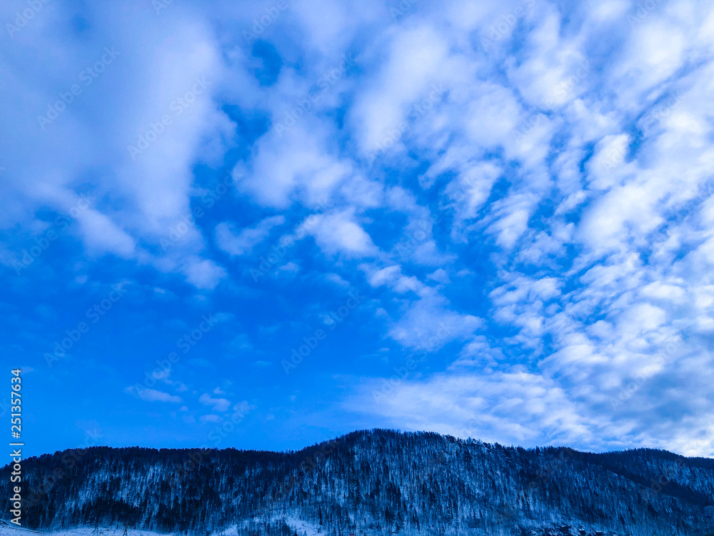 Obraz premium Mountains against a blue sky with clouds