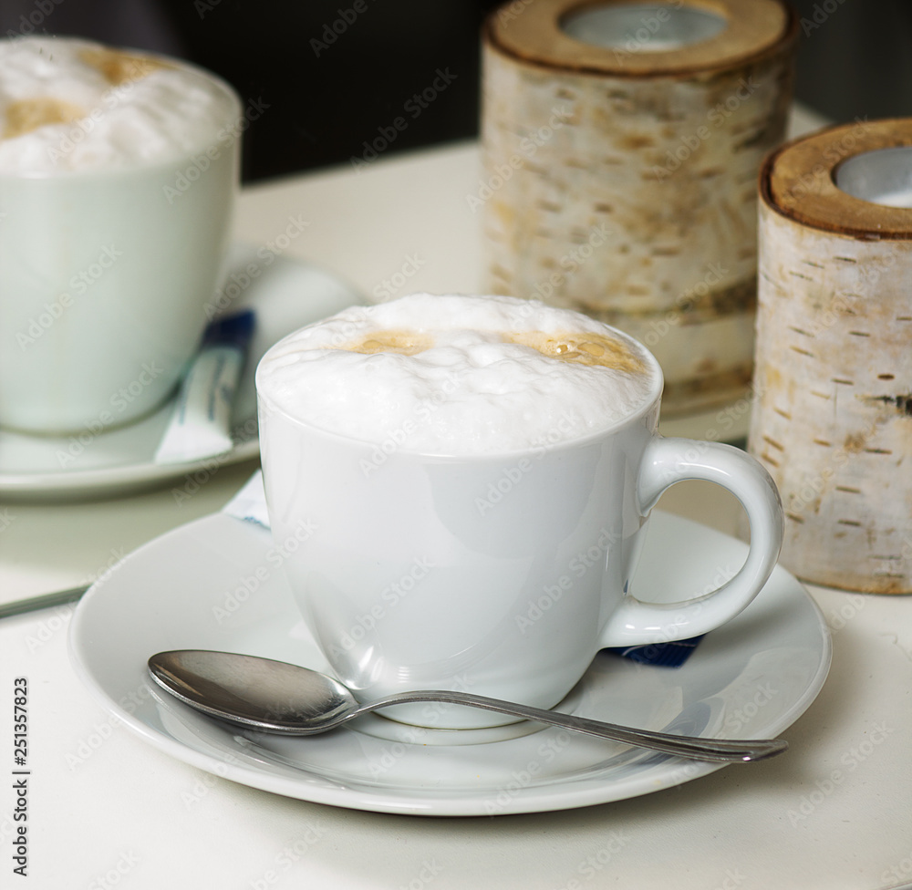 Cup of cappuccino reflecting in mirror