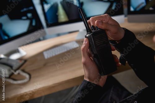 cropped view of guard holding walkie-talkie at workspace photo