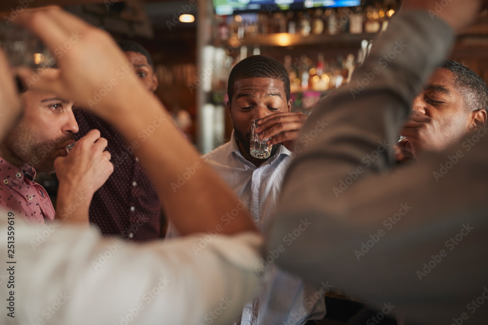 Group Of Male Friends On Night Out Drinking Shots In Bar Together Group Of Male Friends On Night Out Drinking Shots In Bar Together