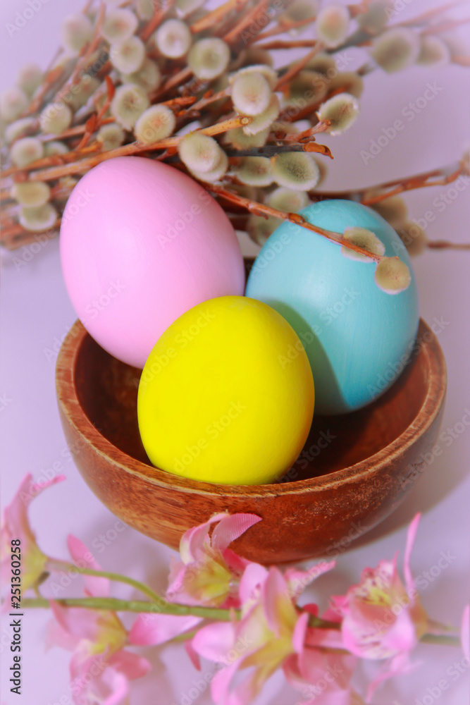 pink yellow blue eggs against a background of willow and flowers for the Easter holiday pink yellow blue eggs against a background of willow and flowers for the Easter holiday