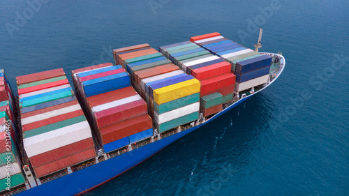 Aerial of cargo ship carrying container and running for export goods from cargo yard port to other ocean concept freight shipping ship on blue sea , logistic service transportation.