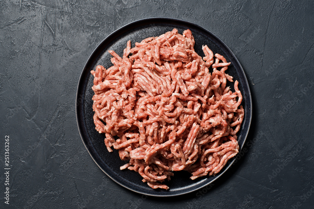 Raw ground beef on a stone Board. Black background, top view, space for text