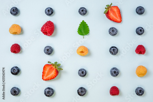 Pattern of berries on blue background. Flat lay mix summer berries background. Creative minimalism. Top view