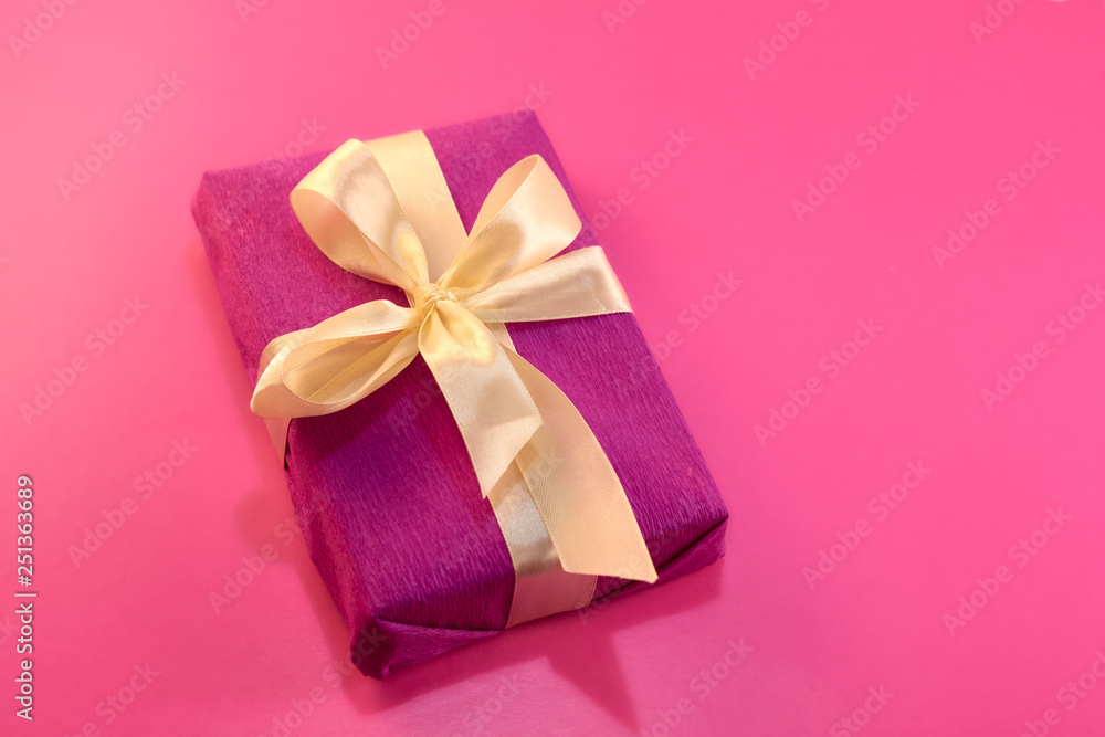gift wrapped and decorated with a light bow on a pink background with copy space. Flat lay, top view. copy space gift wrapped and decorated with a light bow on a pink background with copy space. Flat lay, top view. copy space