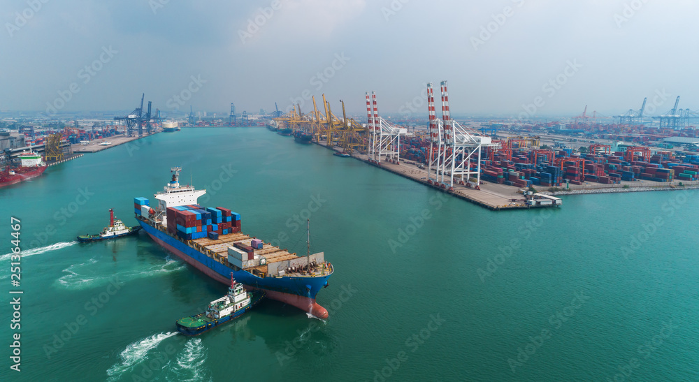 Tug boat drag Container ship to crane bridge at sea port or container warehouse for logistic, import export, shipping or transportation.