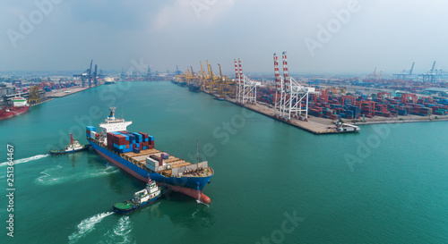 Tug boat drag Container ship to crane bridge at sea port or container warehouse for logistic, import export, shipping or transportation.