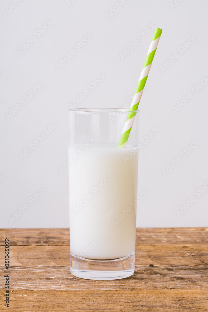Glass of Milk and Straw on Wooden Table Glass of Milk and Straw on Wooden Table