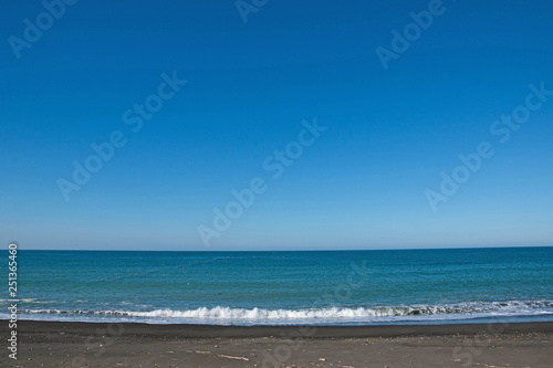 Fototapeta Naklejka Na Ścianę i Meble -  青い海と砂浜に打ち寄せる波