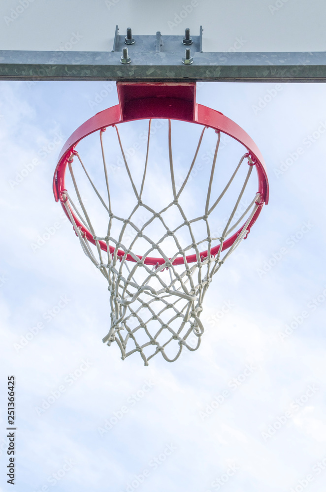 An outdoor basketball hoop set against blue sky.