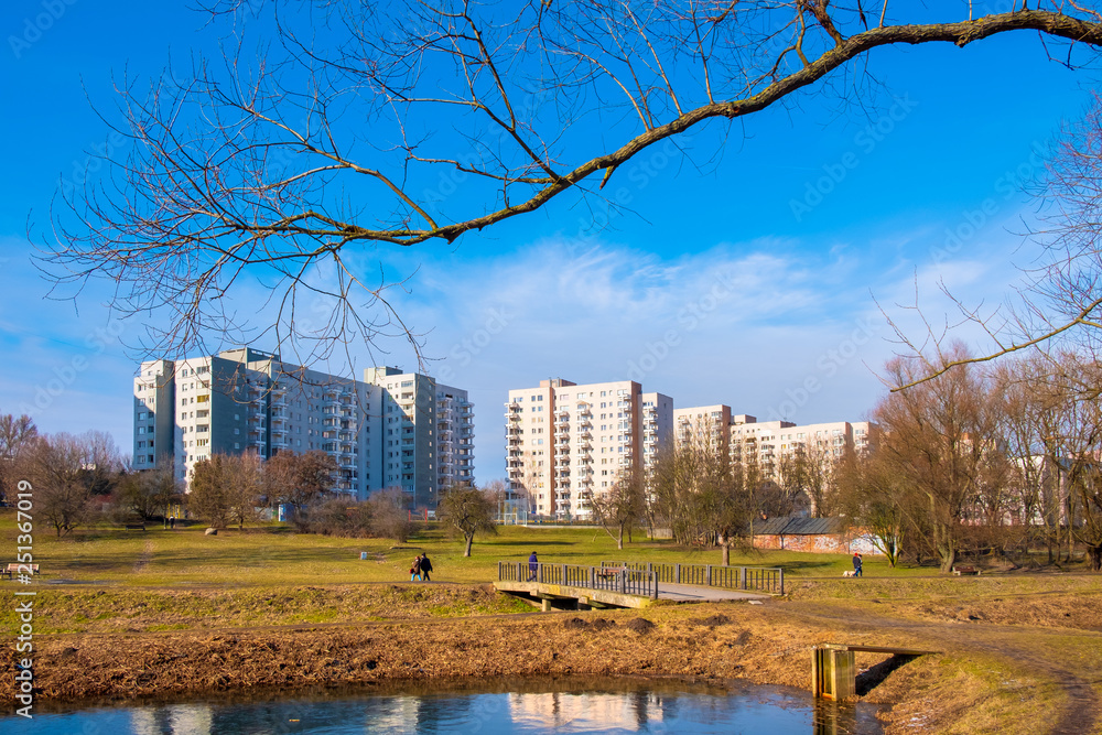 Warsaw, Poland - Dolina Sluzewiecka valley and public park along the Potok Sluzewiecki creek with Mokotow and Sluzew nad Dolinka districts residential architecture in early spring season. Warsaw, Poland - Dolina Sluzewiecka valley and public park along the Potok Sluzewiecki creek with Mokotow and Sluzew nad Dolinka districts residential architecture in early spring season.