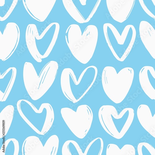 Seamless pattern with hearts hand drawn with rough white contour lines on blu...