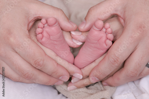 newborn baby feet premature with parents in a heart shape