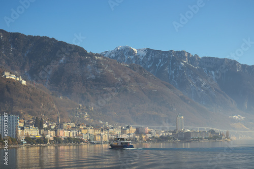 Montreux, Switzerland - 02 17, 2019: Ship cruising towards Montreux with mountains in the background.