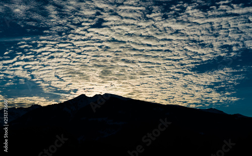 silhouette mountain landscape winter evening with fantastic cloudscape