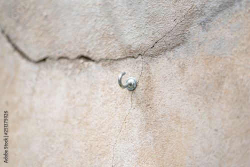 Screw with a hook shape inside a cracked concrete wall