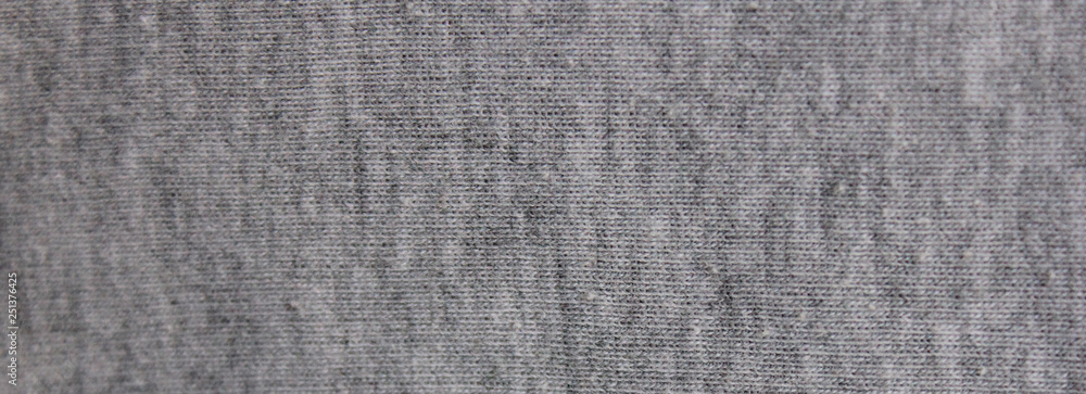 Fototapeta premium Gray fabric texture background of faded grey colored sweater. Cloth surface & material design for empty backdrop, modern fashion clothes pattern. Blank wide canvas and copy space template