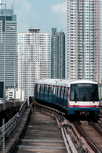 Transportatation by train in Bangkok with train and city skyline at background.