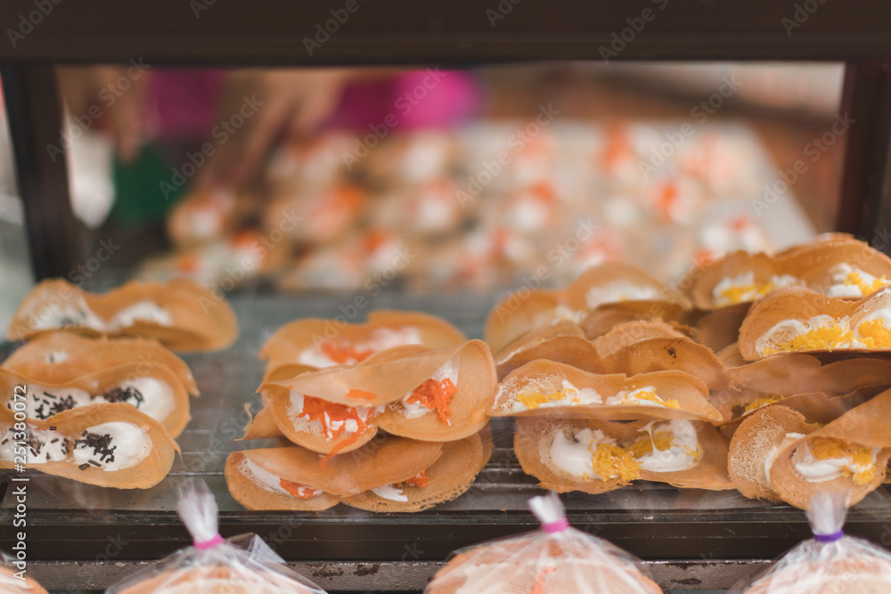 Thai Crispy Pancake in glass cabinet waiting for sell in street food market, front view