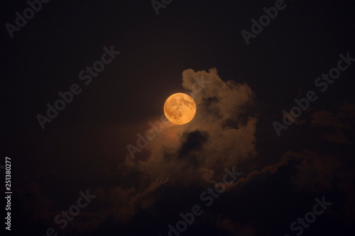Quadro su tela Pleine lune rousse au milieu des nuages de nuit