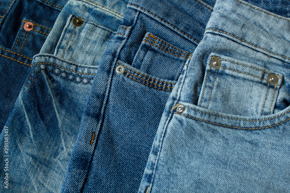 Blue jeans pants clothes pile background. Stack of blue jeans on shop desk Blue jeans pants clothes pile background. Stack of blue jeans on shop desk