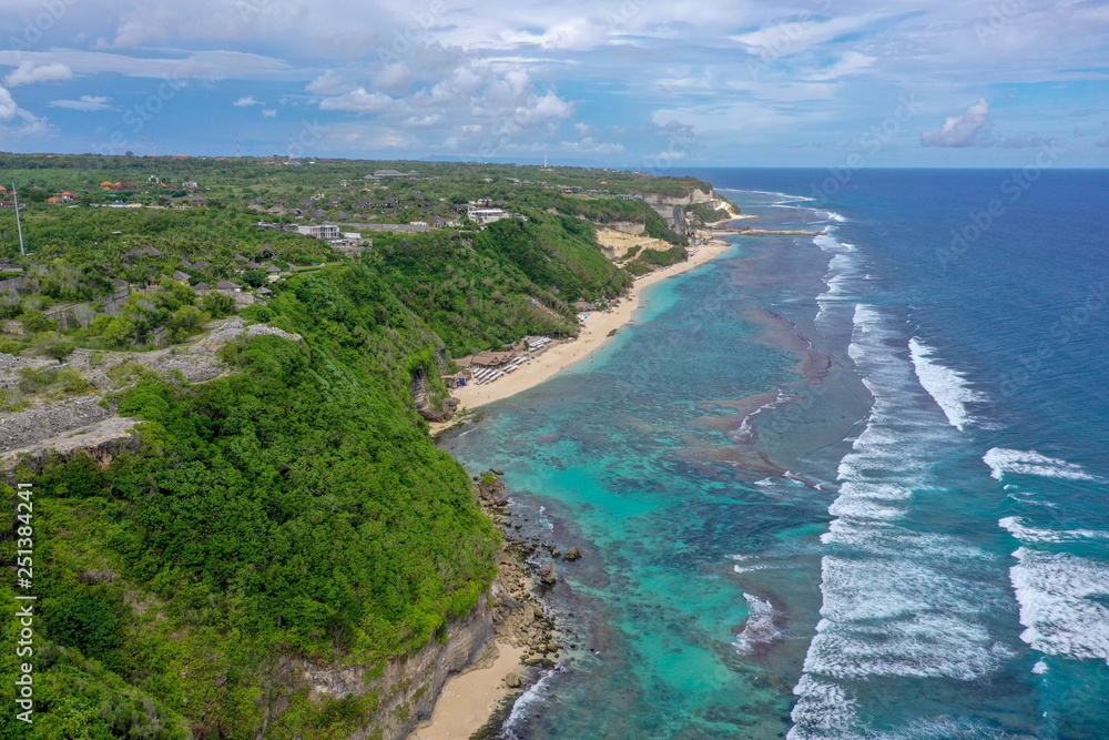 Tropical beach with high green cliffs, aerial view, Melasti beach, Bali, Indonesia