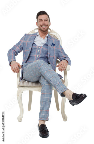 A man in a suit is sitting on an expensive chair.