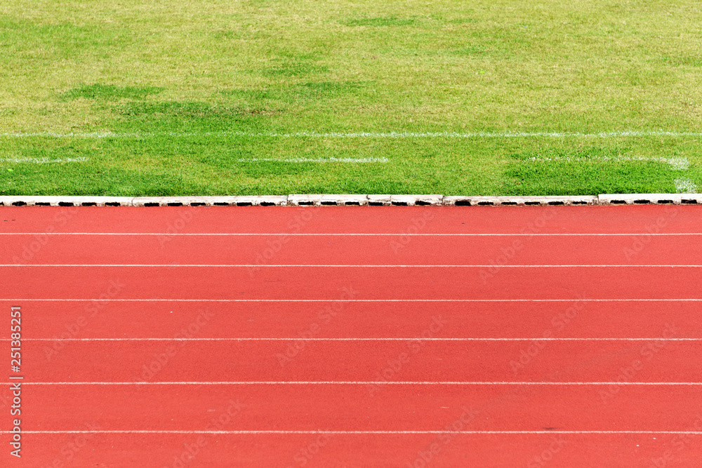 Obraz premium Natural green grass field and orange Running Track background. Success concept or target goal concept.