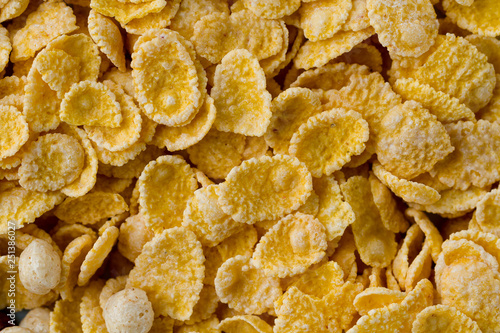 Texture of dry, frosted, glazed yellow corn flakes for cereals breakfast.